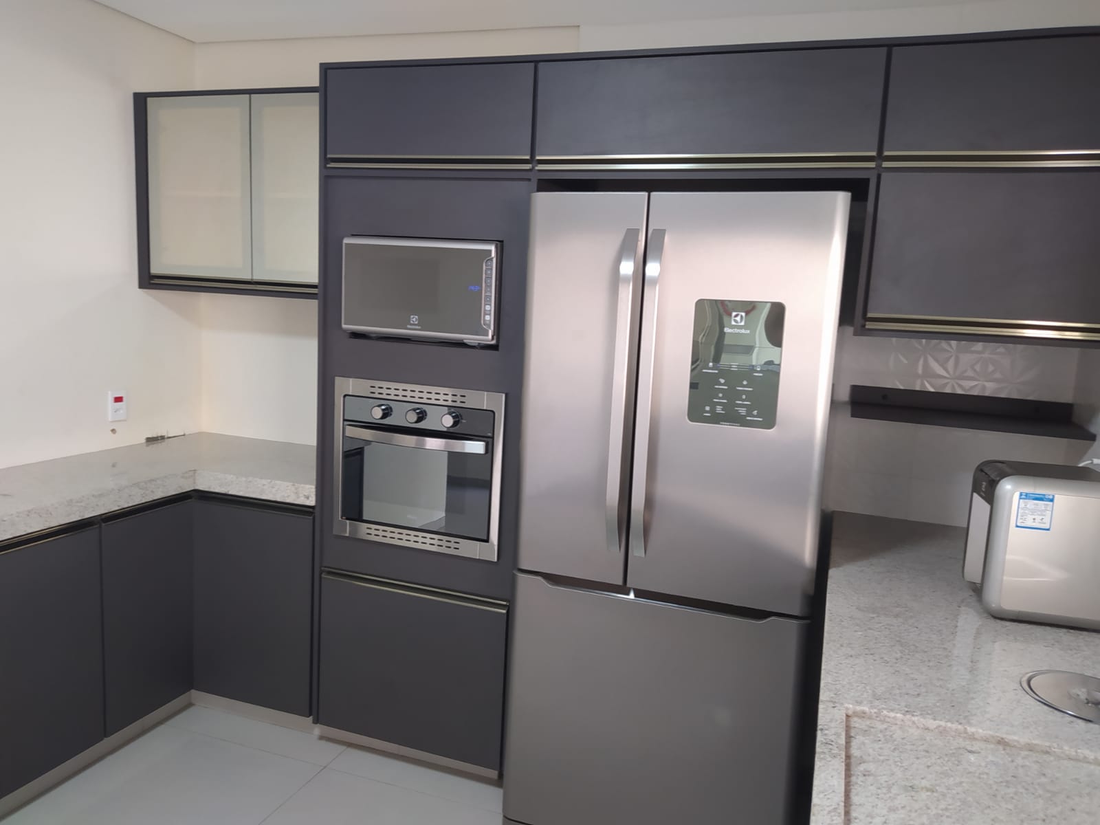 Armário de cozinha planejado com bancada clara e eletros embutidos produzido em Monte Alto SP